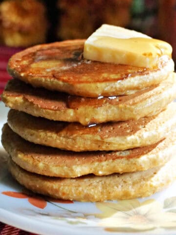 A stack of pancakes topped with butter and syrup.