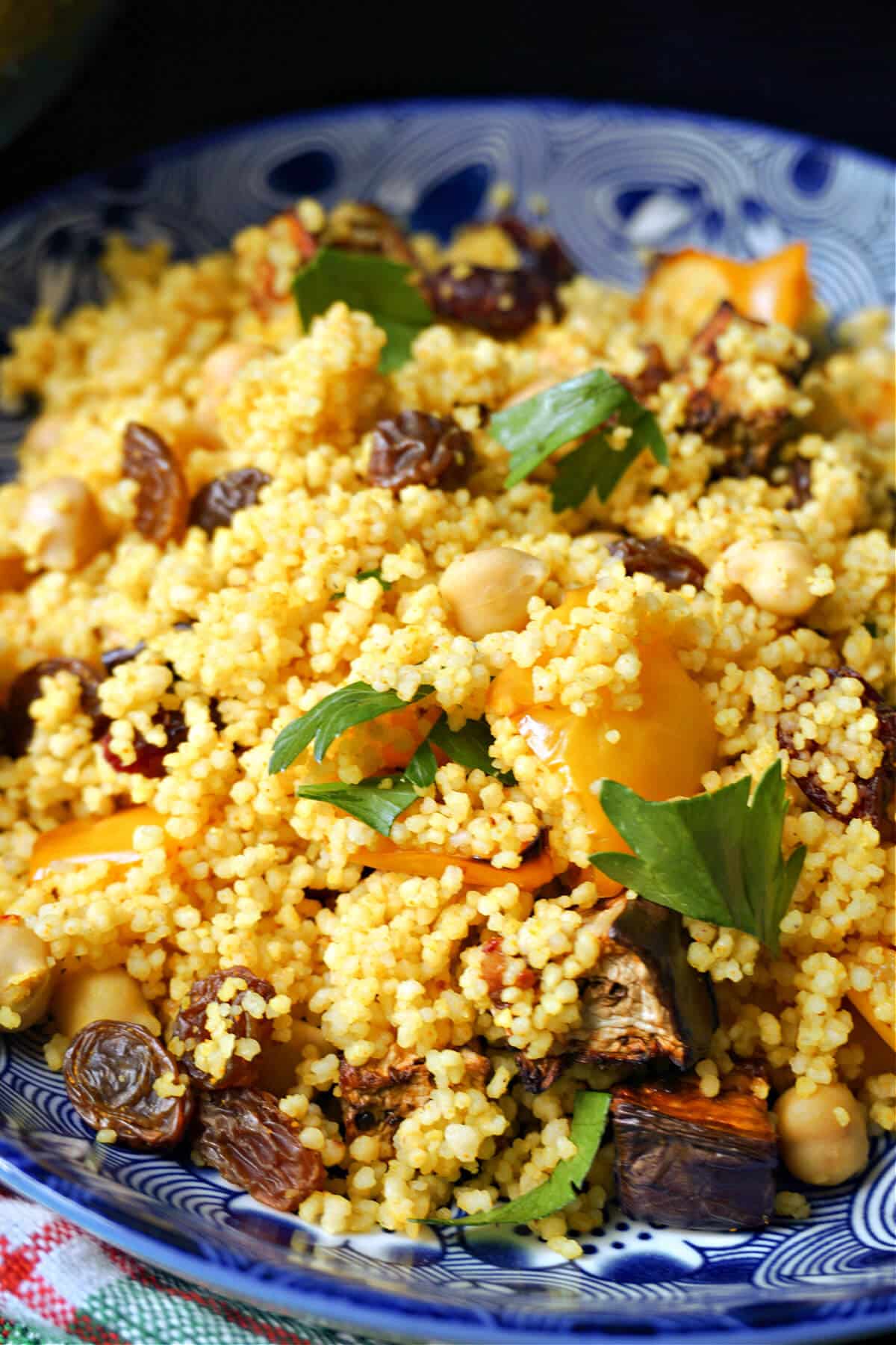 Close-up shoot of a blue plate with couscous salad.