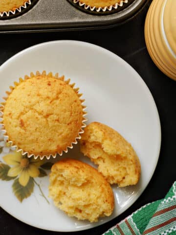 Overhead shoot of a white plate with a whole muffin and 2 halves of a muffin