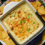 Overhead shoot of a dish with artichoke dip surrounded by nachos