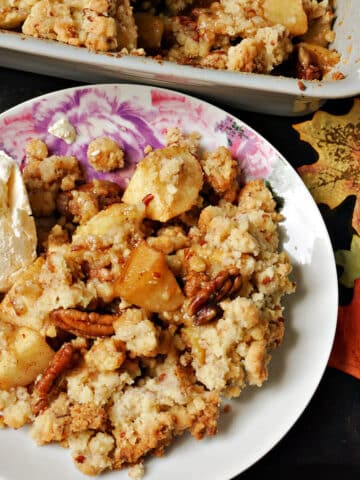 A plate of crumble with apples and pecans.