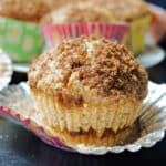 A cinnamon muffin on a muffins case.