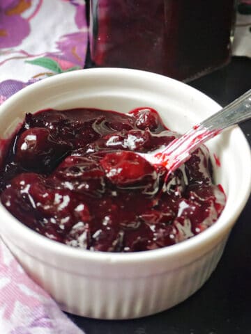 A white ramekin with damson jam.