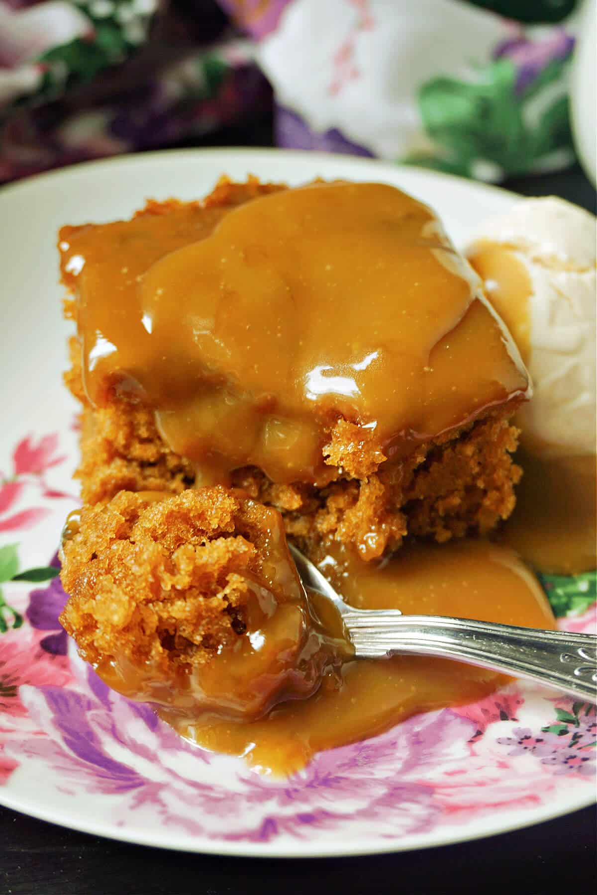 A slice of sticky toffee pudding with toffee sauce on it.