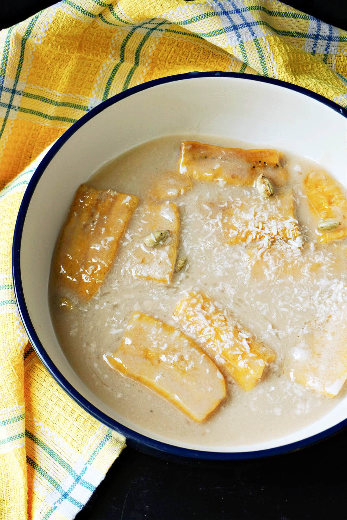 A bowl with plantain slices in coconut milk.
