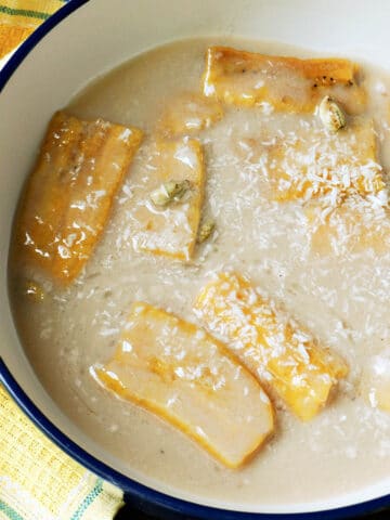 A bowl of plantain slices in coconut milk.