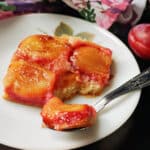 A slice of plum upside down cake on a plate.