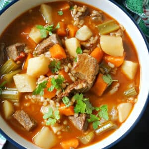 A bowl with vegetable beef barley soup.