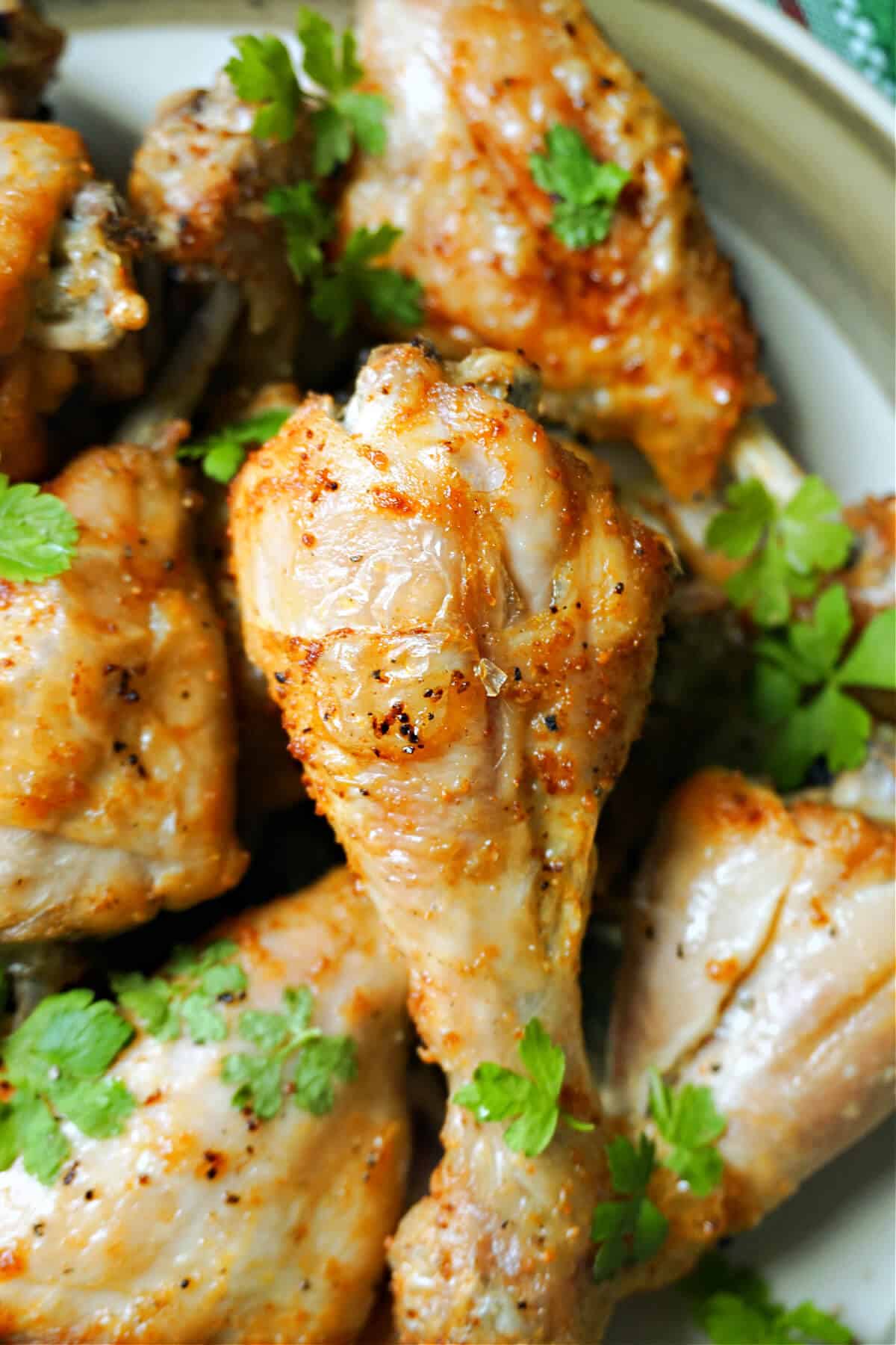 Close-up shoot of chicken drumsticks garnished with parsley.