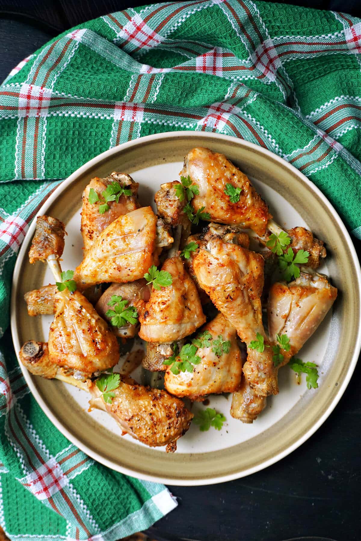 Overhead shoot of a plate with baked chicken drumsticks.