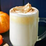 A glass of white hot chocolate with pumpkin.