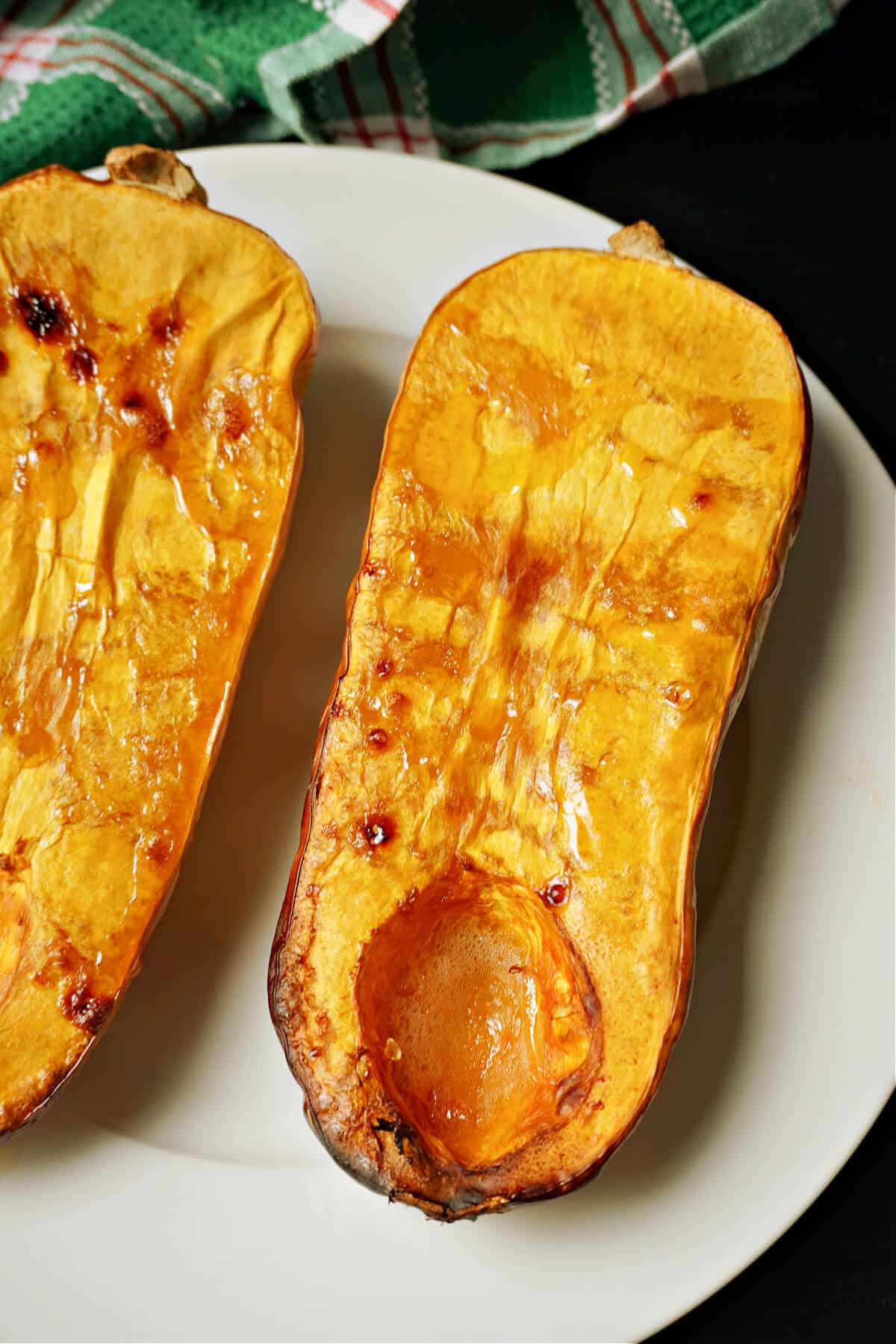 2 roasted butternut squash halves on a plate.