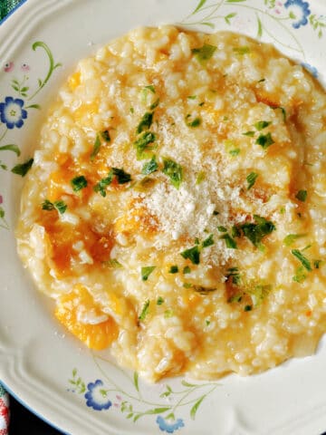 A white plate with butternut squash risotto.