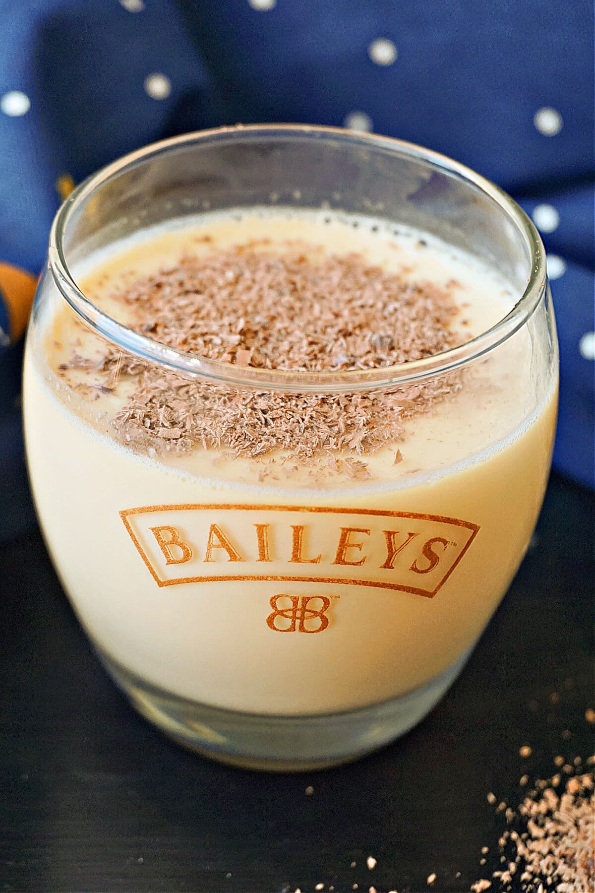 A glass of baileys panna cotta garnished with grated chocolate.