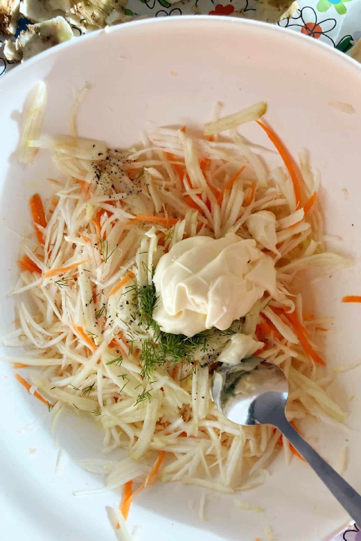 A bowl with ingredients needed for celeriac coleslaw.