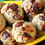 Close-up shoot of chestnut and cranberry stuffing balls in a yellow bowl.