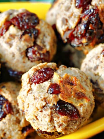 Close-up shoot of chestnut and cranberry stuffing balls in a yellow bowl.