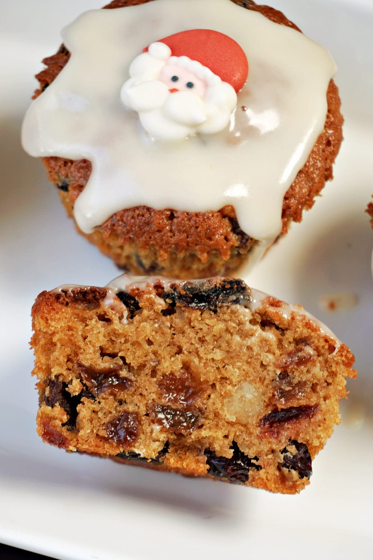 Half of a fruit cake with a whole mini cake next to it.