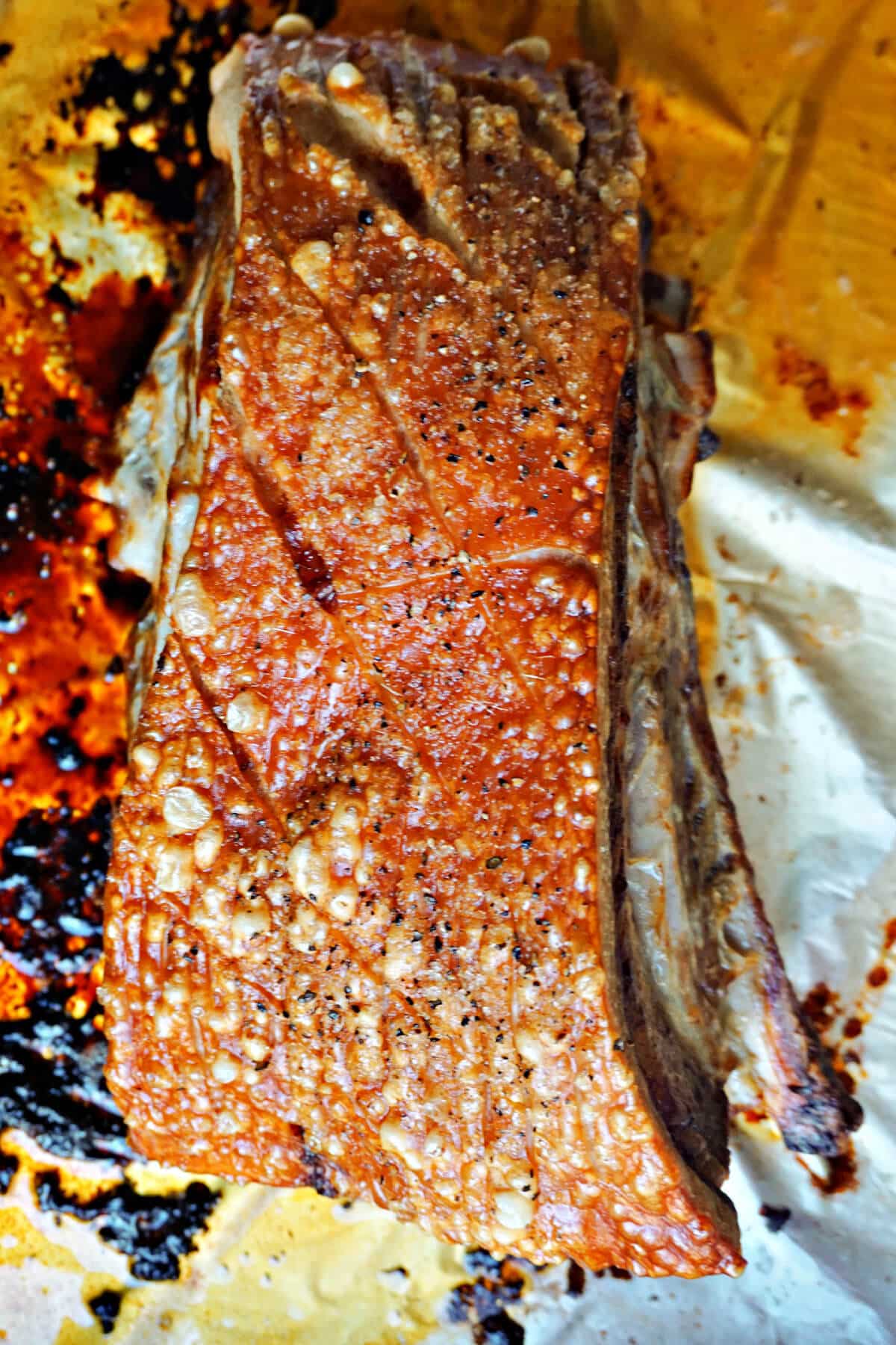 A chunk of roast pork belly on a roasting tin.