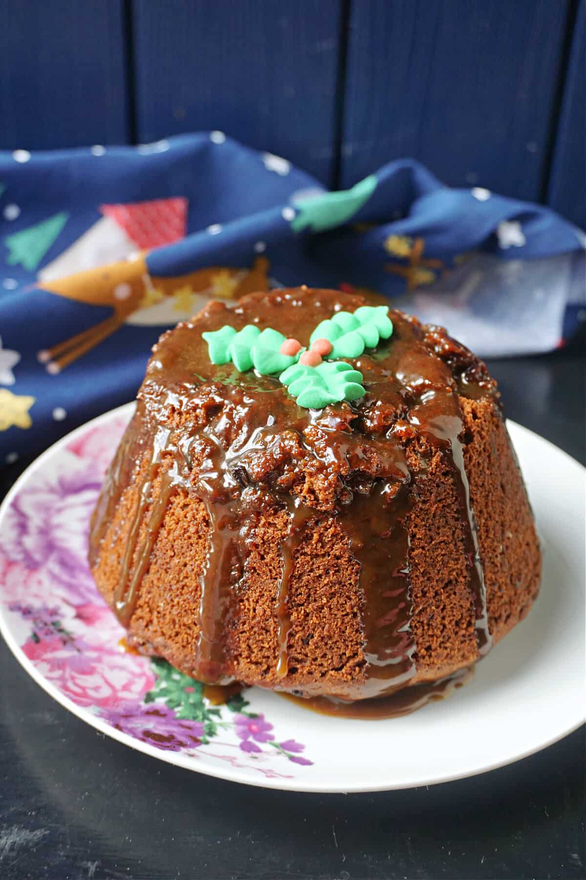 A Christmas sticky toffee pudding on a white plate.