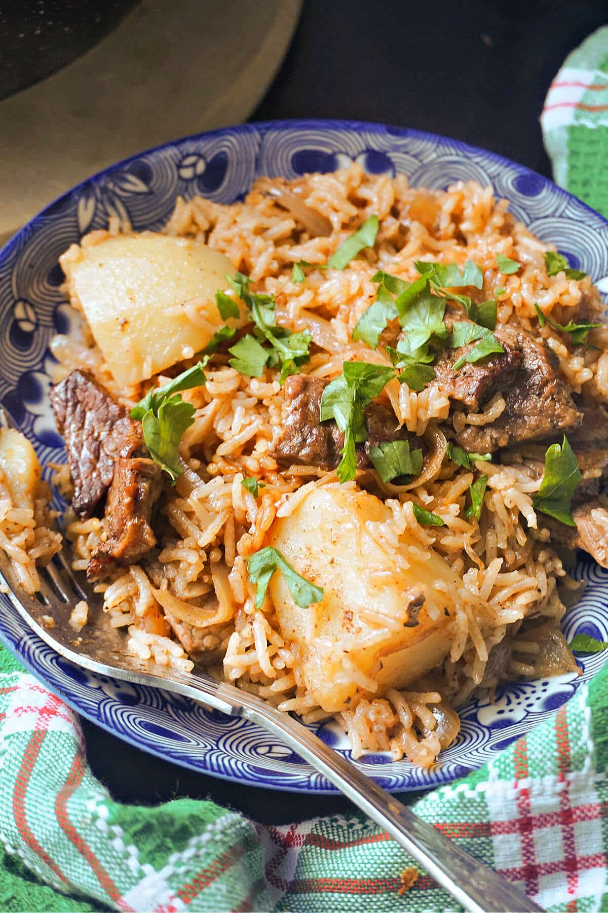 A blue plate with beef pilau.