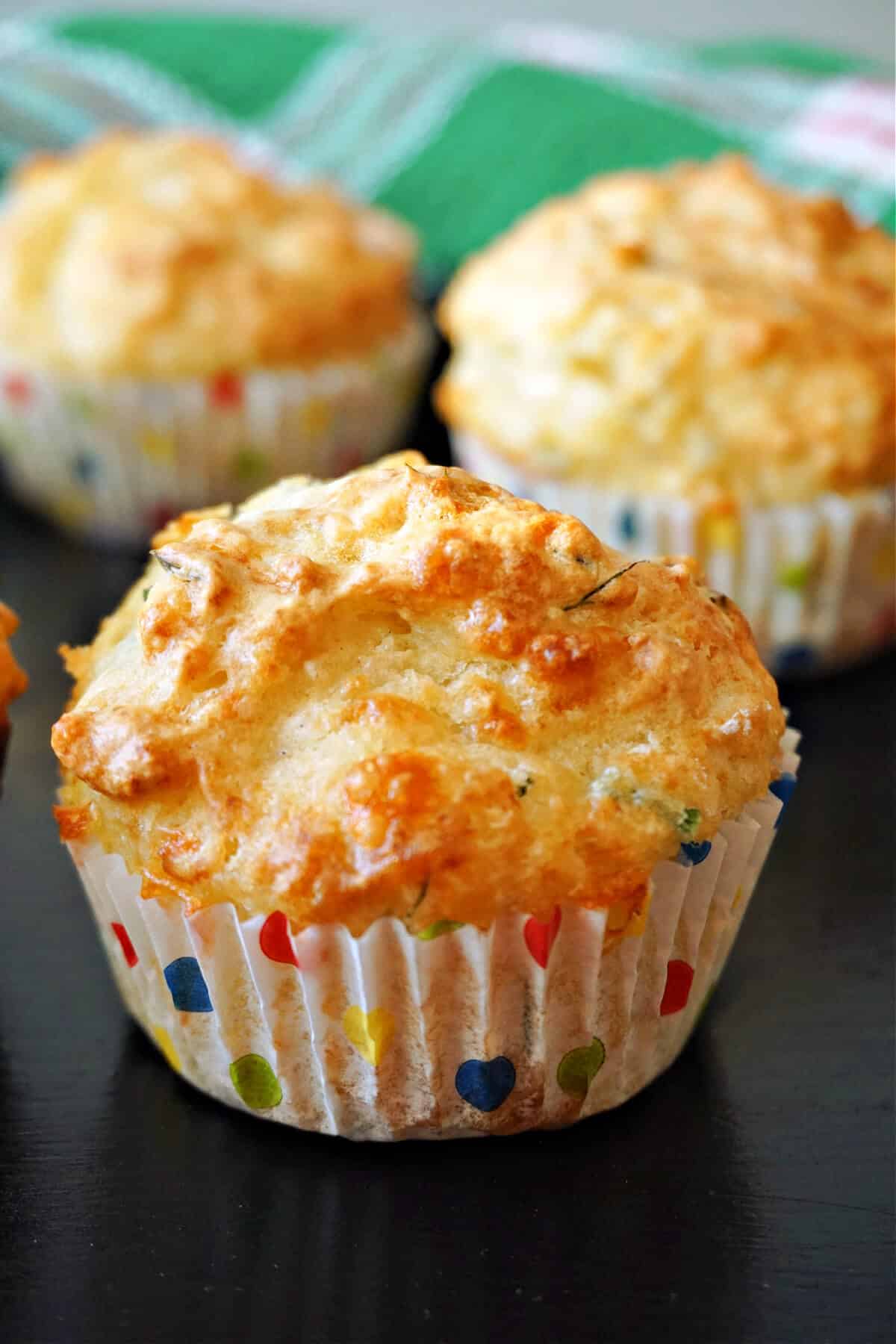 A soda muffin with 2 other muffins in the background.