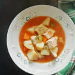 A white plate with turkey stew.
