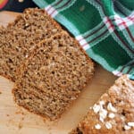 2 slices of brown bread on a wood board.