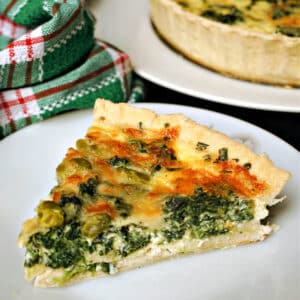 A slice of Coronation quiche on a white plate.