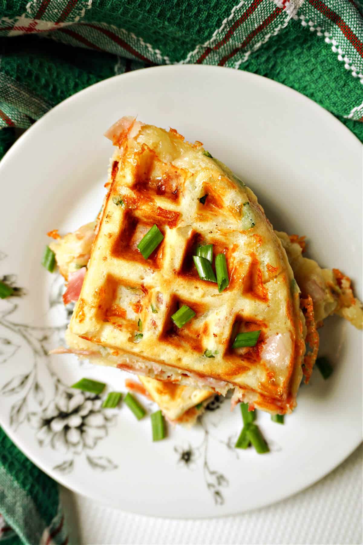 2 waffles garnished with spring onions on a white plate.