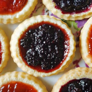 Close-up shoot of a jam tart with other tarts around it.