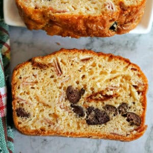 A slice of savoury loaf on a worktop with a partially visible slice of loaf at the top.