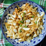 A blue plate with cabbage stir fry.