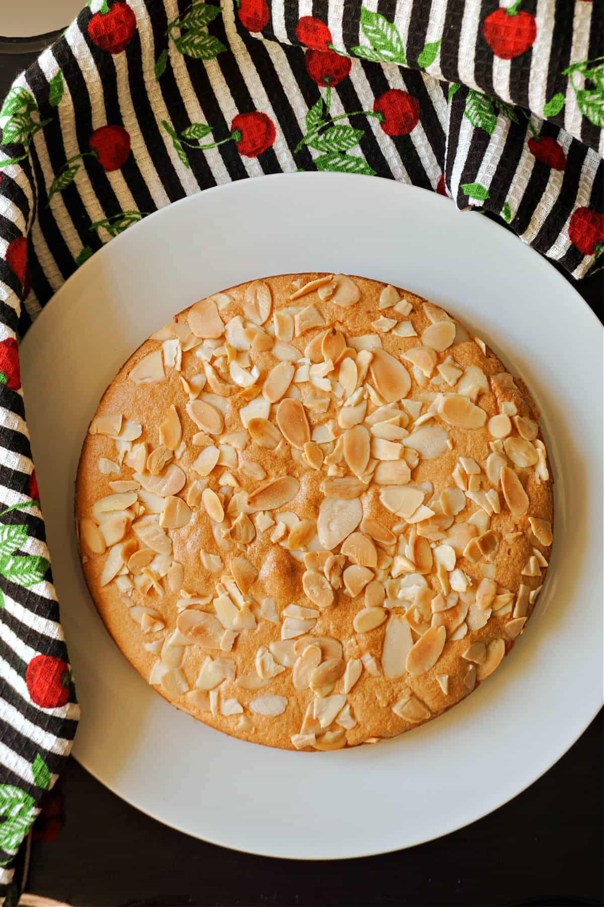 An almond cake on a white plate.