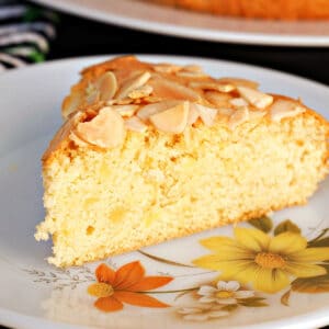 A slice of almond sponge cake on a plate.