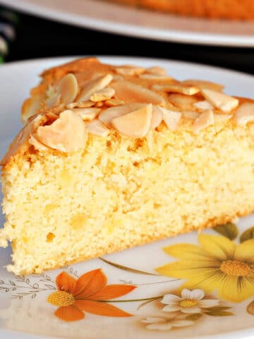 A slice of almond sponge cake on a plate.