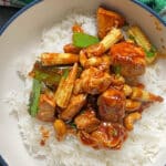 A white and blue bowl with chicken cashew stir fry.