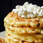A pile of cottage cheese pancakes with a dollop of cottage cheese inside.