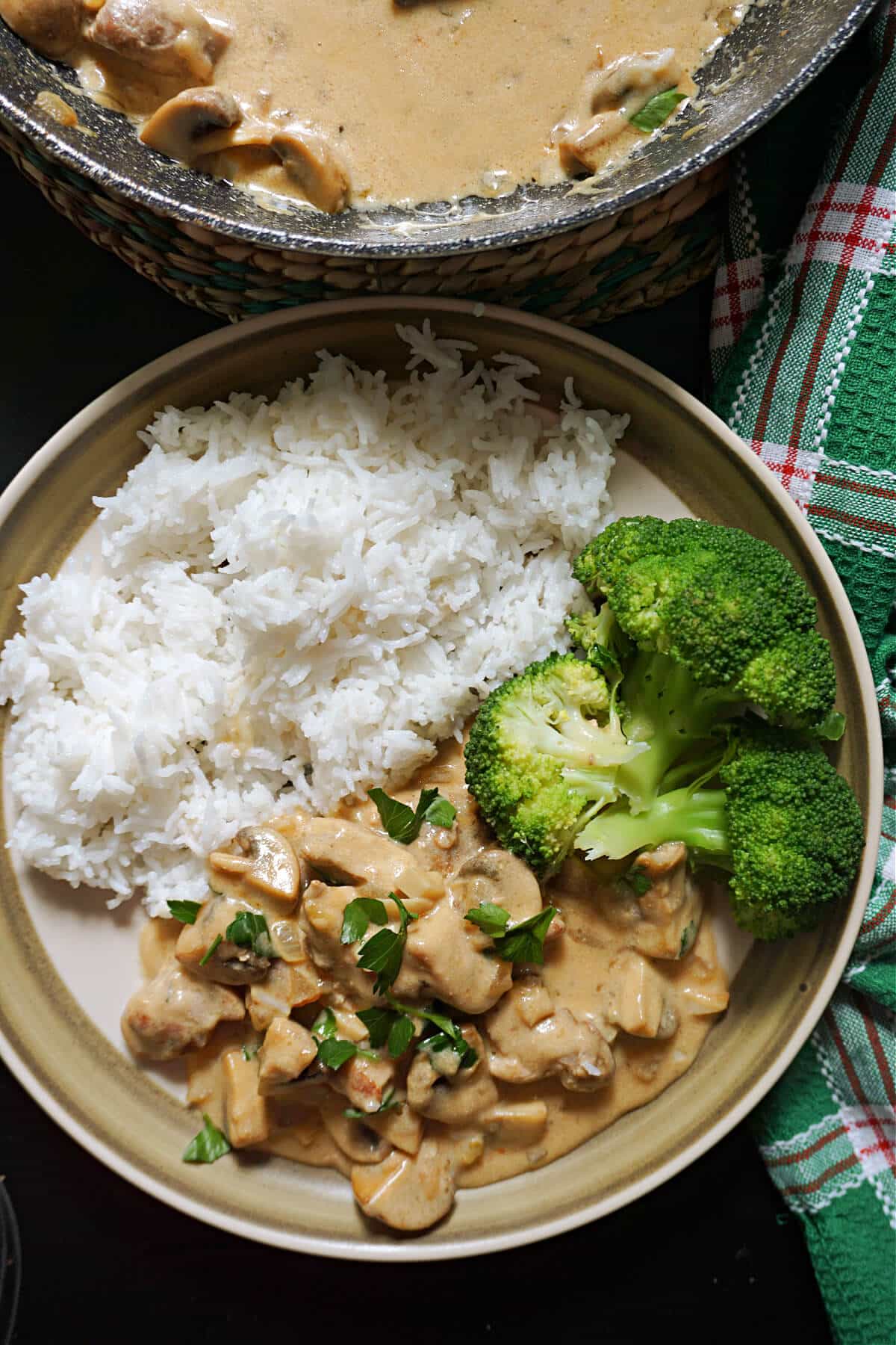 A plate with basmati rice, broccoli florets and pork stroganoff.