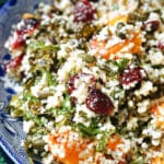 A blue plate with a portion of kale, butternut squash and couscous salad.