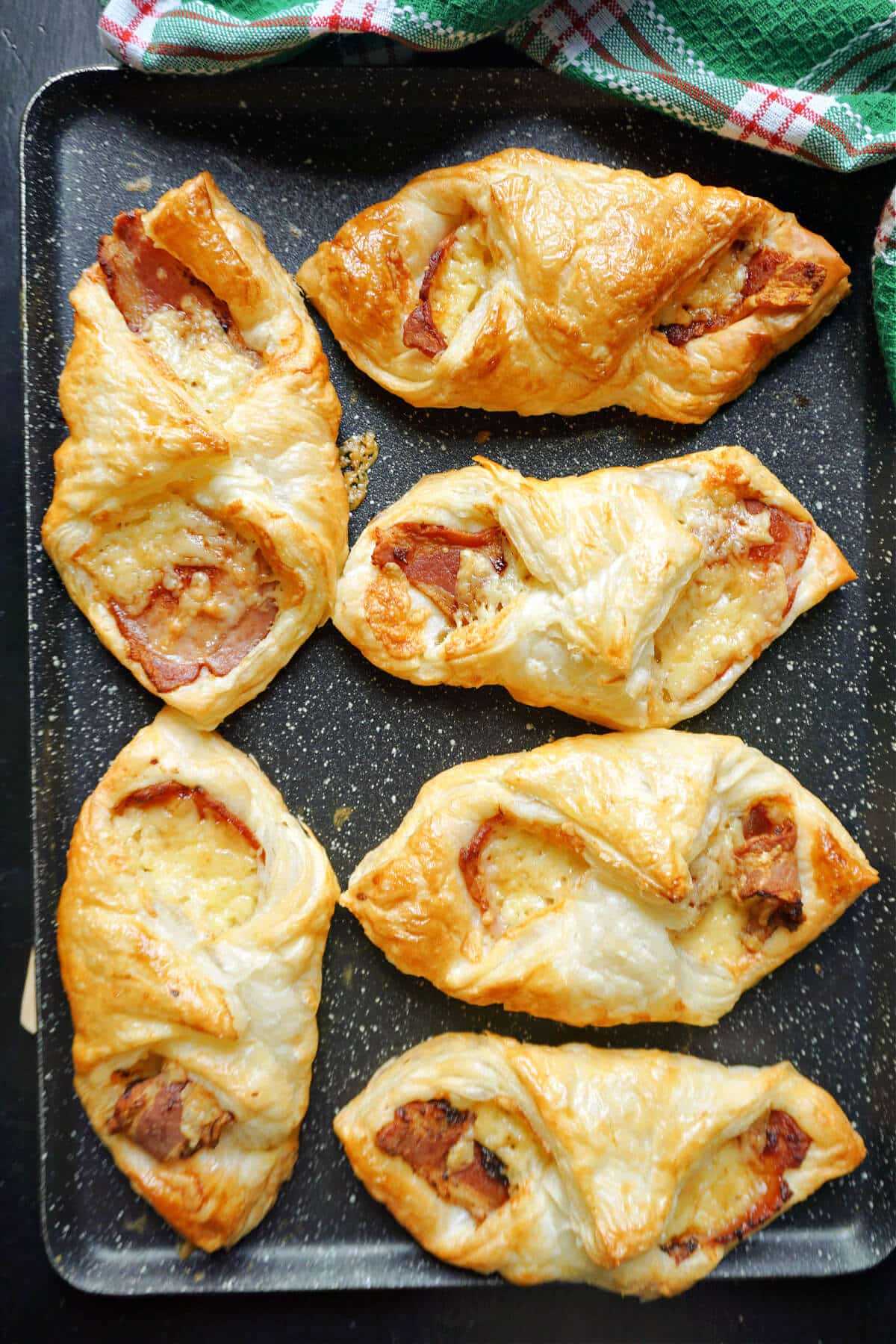 A baking tray with 6 bacon and cheese turnovers.