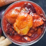 Overhead shoot of a dessert glass with plum compote.