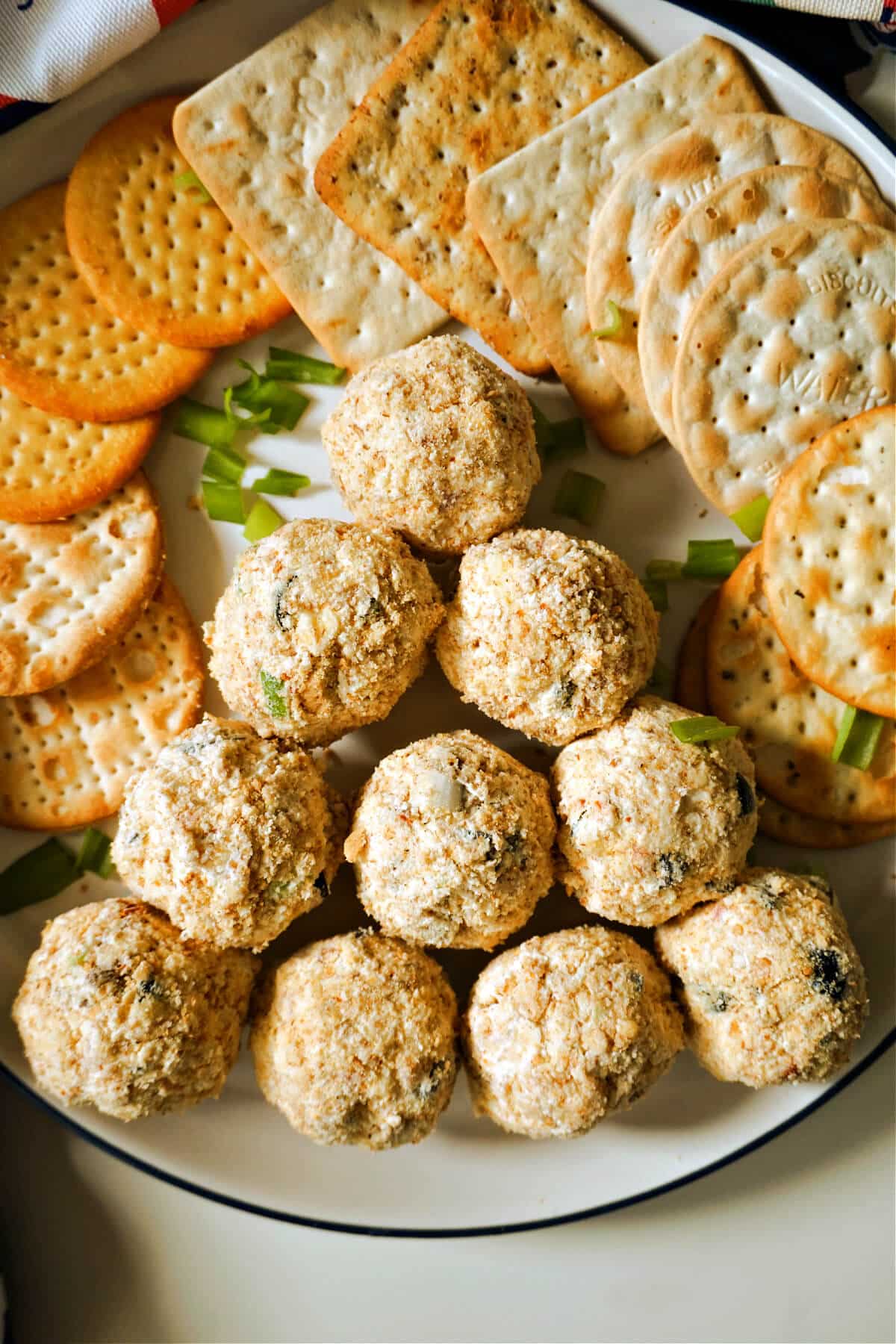 A plate with mini cream cheese balls and crackers around them.