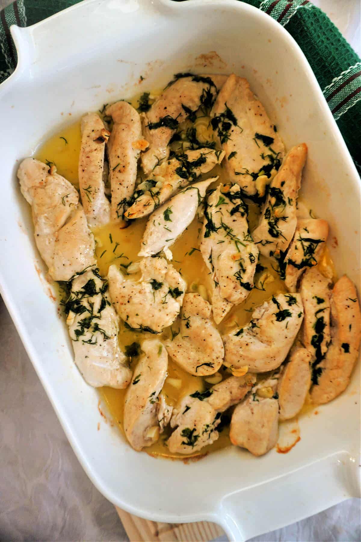 A white dish with baked chicken tenders.