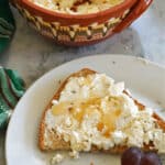 A slice of toast with ricotta and honey on top.