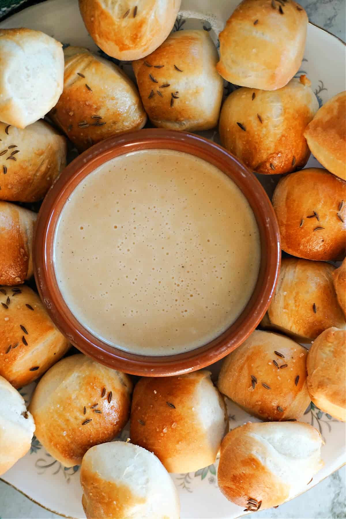 Overhead of a ramekin with Guinness dip and pretzel bites around it.