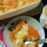 A plate with a portion of apple and sponge pudding on a plate.