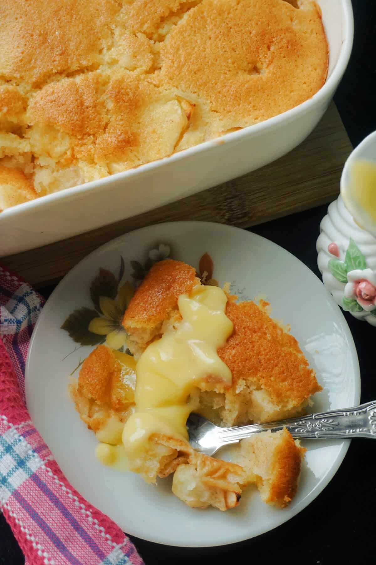 A small plate with a portion of apple dessert and a dish with more dessert at the top.