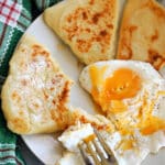 A plate with 3 potato cakes and a fried egg.