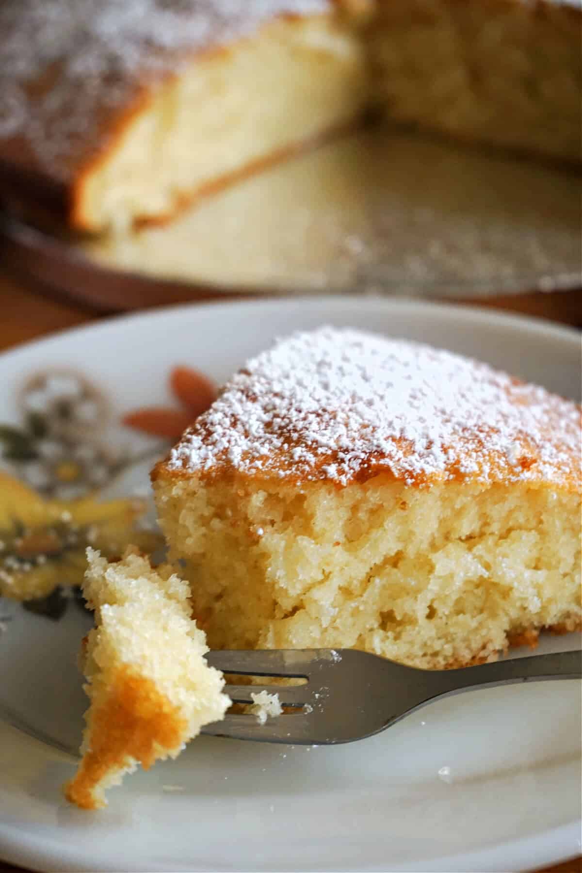 A slice of sponge cake on a white plate.